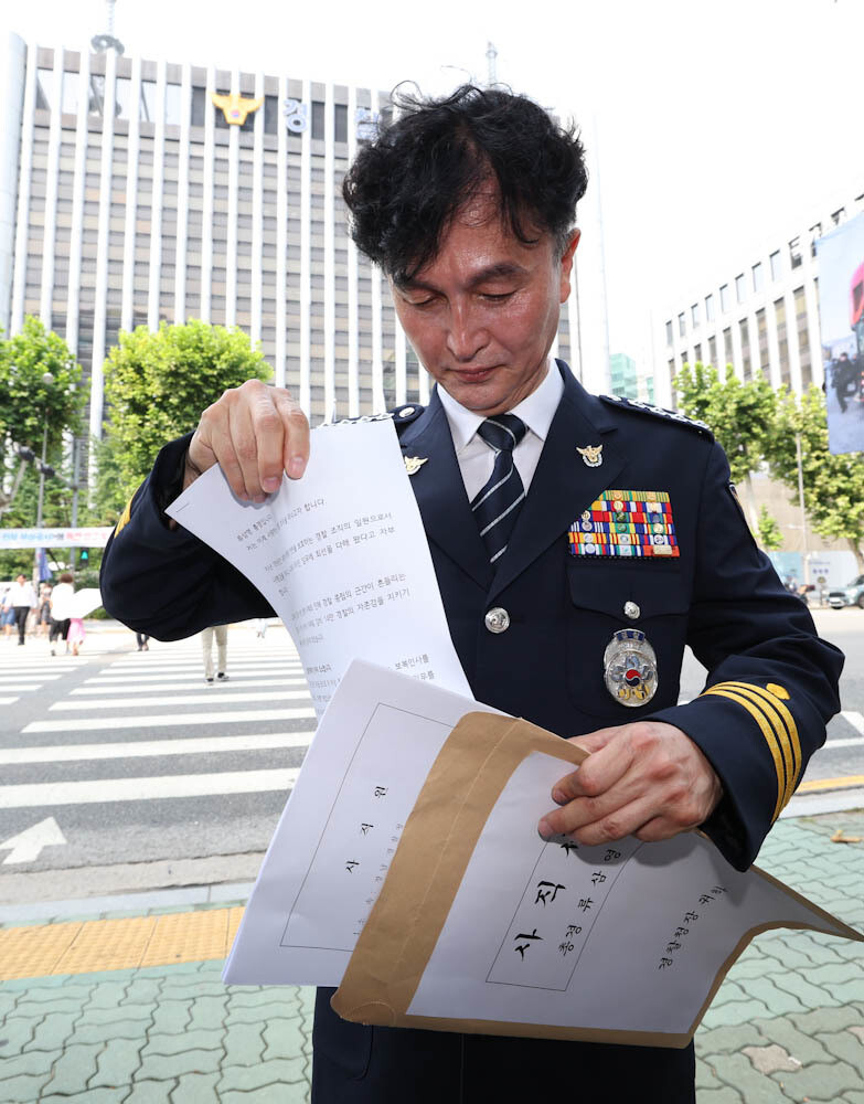 류삼영 총경이 31일 오전 서울 중구 경찰기념공원에서 기자회견을 열어 “사직하겠다” 고 밝힌 뒤 사직원이 담긴 봉투에 사직 이유를 쓴 글을 출력한 종이를 넣고 있다. 김정효 기자