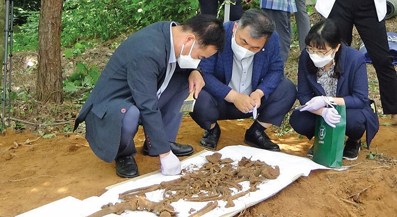 2021년 6월24일 5·18민주화운동조사위원회 조사관들이 전남 해남군 해남읍의 한 야산에서 무연고 유골을 발굴해 살펴보고 있다.5·18조사위 보고서 갈무리