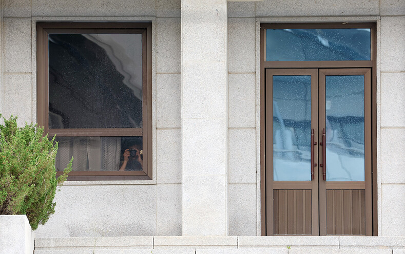 판문점 견학이 재개된 가운데 19일 판문점 내 북쪽 판문각 창문 틈으로 북한군이 남쪽을 향해 카메라를 들고 있다. 연합뉴스