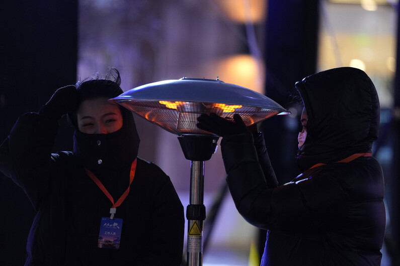 16일 중국 베이징에서 노동자들이 실외 난로에서 몸을 녹이고 있다. 베이징/AP 연합뉴스