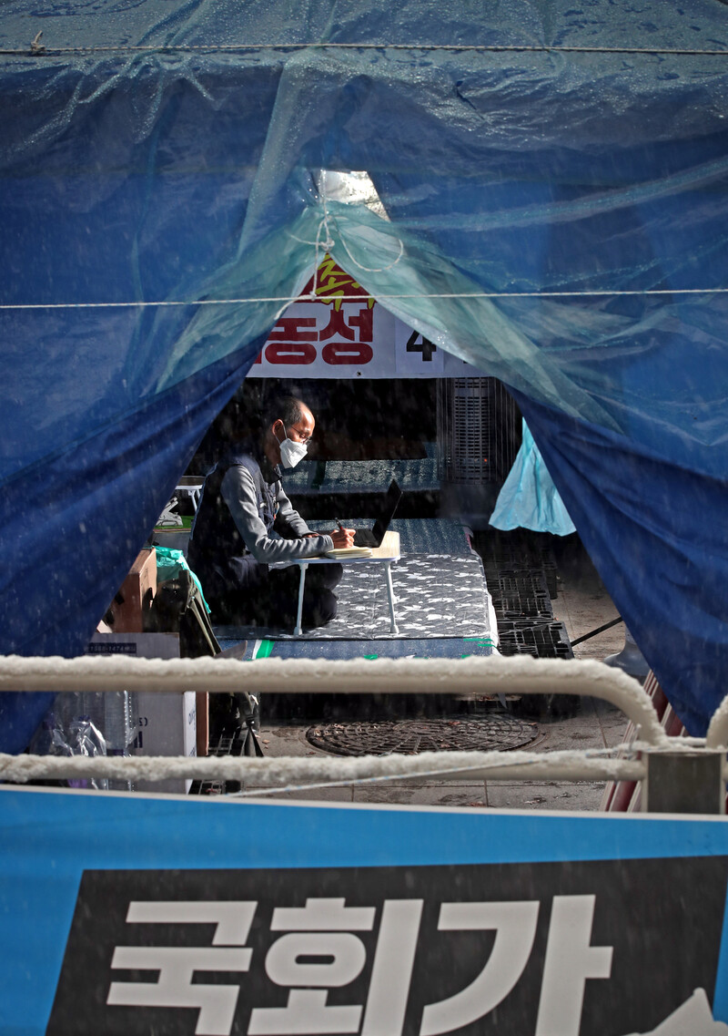 민주노총 공공운수노조 화물연대본부의 파업은 정부의 강경한 대응에 밀려 16일 만에 철회됐다. 하지만 이봉주 화물연대 위원장은 ‘안전운임제 3년 연장’ 약속만이라도 지키라며 파업 철회 사흘 뒤인 12일 서울 여의도 국회의사당 앞에서 무기한 단식농성을 시작했다. 국회가 연장안을 처리하지 않으면, 안전운임제는 올해 말 종료된다. 이 위원장은 “(파업이) 정부가 한 약속을 지키라는 투쟁이자 도로 위에서 죽고 싶지 않다는, 사회안전망에 넣어달라는 화물 노동자들의 절규”라고 호소하고 있다. 사진은 지난 15일 오후 농성장을 지키고 있는 이봉주 위원장. 이정용 선임기자 lee312@hani.co.kr