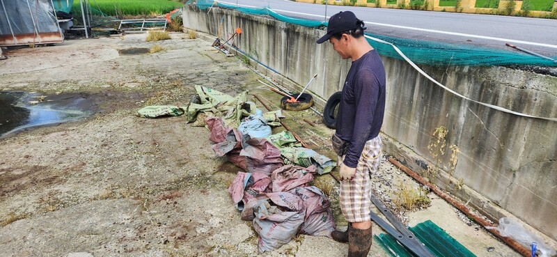 침수 피해를 본 전남 무안군 일로읍 태두농장 박성진 대표가 25일 오리 사체를 담은 포대를 살펴보고 있다.