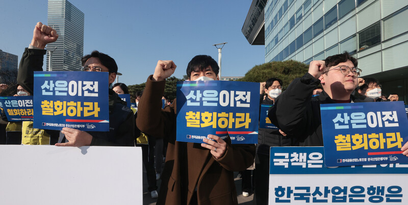 산업은행 노동조합원들이 지난 3월 서울 영등포구 KDB 산업은행 본점 앞에서 열린 부산이전 강행 규탄 결의대회에서 이전 계획 철회를 요구하는 팻말을 들고 구호를 외치고 있다. 연합뉴스