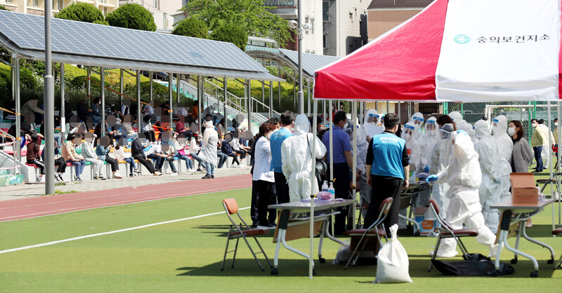 20일 인천시 미추홀구 미추홀구청 운동장에 마련된 코로나19 선별진료소에 검체 검사를 받으러 온 시민들이 줄지어 들어서고 있다. 연합뉴스