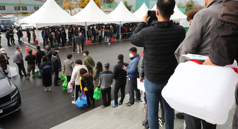 9일 전북 익산시 실내체육관 앞에 요소수를 구매하려는 인파가 몰려 있다. 전북 익산시와 호남 유일의 요소수 생산업체인 아톤산업은 이날부터 지역민에게 요소수를 직접 판매하기로 했다. 토·일요일·공휴일을 제외한 평일 오전 10시부터 오후 4시까지 요소수를 판매한다. 익산/연합뉴스