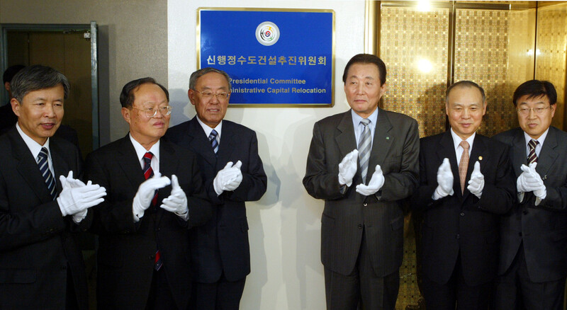 고건 국무총리가 2004년 5월21일 오후 정부 중앙청사에서 거행된 신행정 수도건설추진위원회 현판식에서 위원들과 함께 박수를 치고 있다. 왼쪽부터 이정우 청와대정책기획위원장, 강용식 자문위원장, 김안제 위원장, 고 총리, 강동석건교부 장관, 김영주 추진단장. 연합뉴스