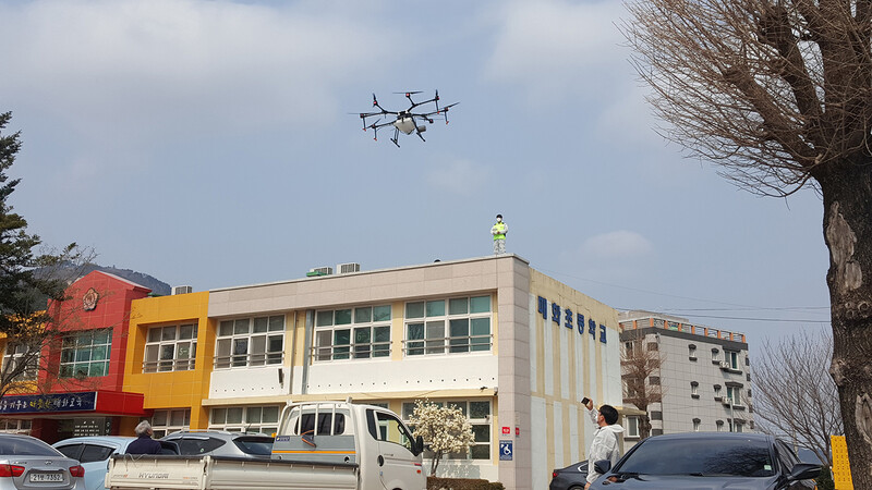 7일 경북 울진군 매화면 매화초등학교에서 방역당국 관계자들이 드론을 이용해 방역소독을 하고 있다. 울진군 제공