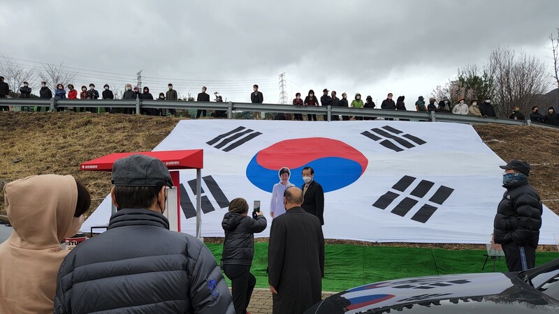 18일 대구시 달성군 유가읍 쌍계리 박근혜 전 대통령 집 앞에서 박 전 대통령 귀향을 환영하는 행사가 열린 가운데 지지자들이 태극기를 배경으로 박 전 대통령 등신대 옆에 서서 사진을 찍고 있다. 김규현 기자 <a href="mailto:gyuhyun@hani.co.kr">gyuhyun@hani.co.kr</a>