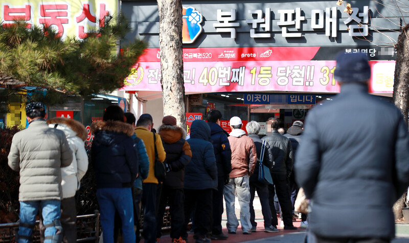 지난해 설 연휴 다음날인 2월7일 서울 노원구의 로또 명당으로 알려진 복권판매점 앞에 시민들이 복권 구입을 위해 줄지어 서서 차례를 기다리고 있다. 연합뉴스