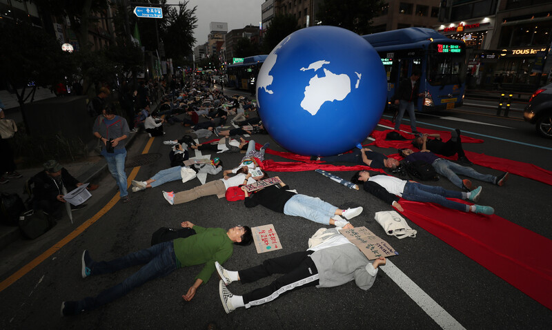 지난해 9월21일 시민사회단체 연대기구인 ‘기후위기비상행동’에 참여한 시민들이 서울 종로구 종로타워 앞에서 날로 심각해지는 기후위기에 맞서 적극적인 온실가스 감축 정책 등을 요구하며 ‘불타는 지구’에서 더는 살 수 없음을 뜻하는 상징 의식을 하고 있다. 김정효 기자 hyopd@hani.co.kr