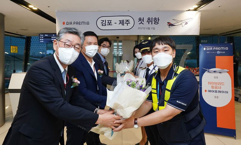 11일 아침 김포공항 출발장서 열린 에어프레미아 김포-제주 노선 취항식에서 심주엽 대표(왼쪽에서 세번째), 이종철 제이씨(JC)파트너스 대표(두번째), 백순석 샤프 에비에이션 케이(K) 대표(첫번째)가 승무원 및 임직원들에게 꽃다발을 전달하고 있다. 에어프레미아 제공