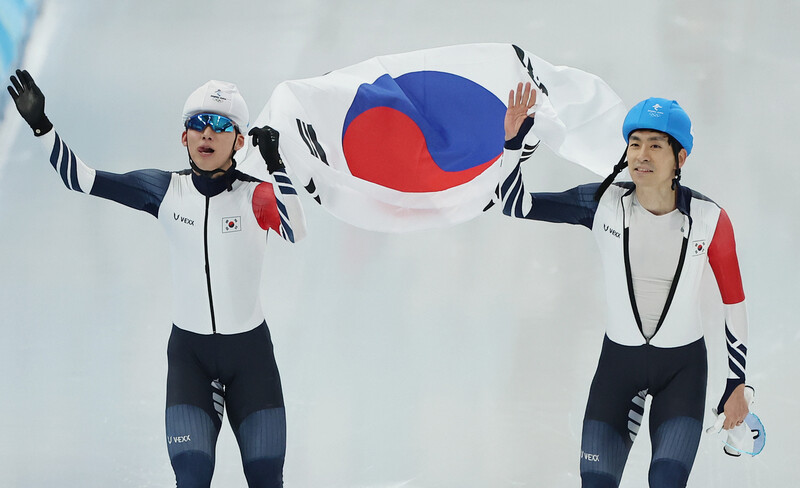 정재원(왼쪽)과 이승훈이 19일 중국 베이징 국립 스피드스케이팅 경기장에서 열린 2022 베이징겨울올림픽 스피드스케이팅 남자 매스스타트 결승에서 은메달과 동메달을 따낸 뒤 태극기를 휘날리며 기뻐하고 있다. 베이징/연합뉴스