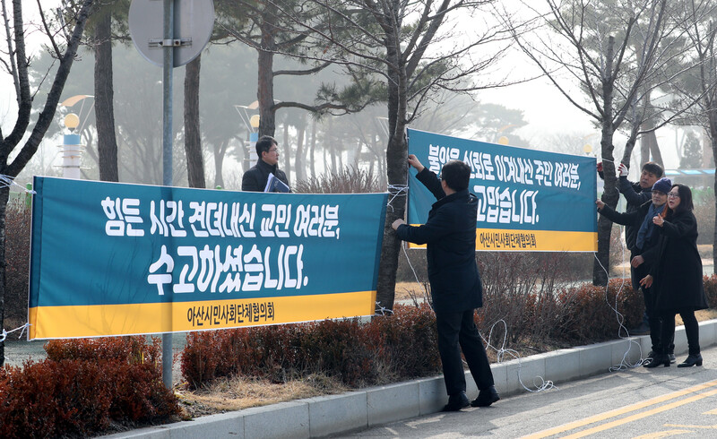 중국 후베이성 우한 교민들이 생활하고 있는 충남 아산 경찰인재개발원 앞에 14일 오전 아산시민사회단체협의회 관계자들이 우한 교민을 위로하고 아산 주민에게 고마움을 전하는 내용의 펼침막을 걸고 있다. 지난달 31일과 이달 1일 1,2차 전세기로 귀국해 이곳과 충북 진천 국가공무원인재개발원에서 생활한 우한교민들은 15일과 16일 퇴소한다. 아산/김정효 기자 hyopd@hani.co.kr
