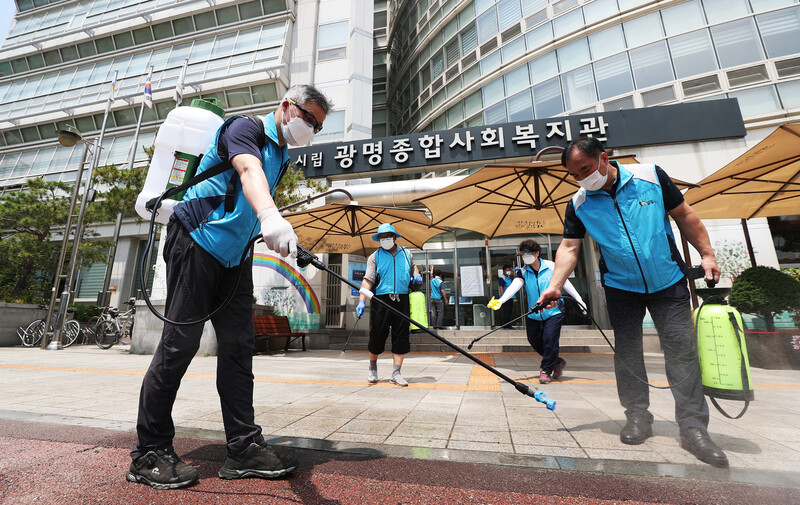 코로나19 확진자 6명이 추가로 나온 경기 광명시 광명어르신보호센터 앞에서 9일 오후 광명3동 자율방재단원들이 소독을 하고 있다. 연합뉴스