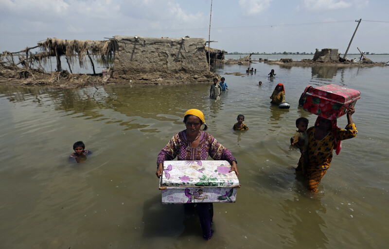 지난해 여름 큰 홍수가 발생한 파키스탄 남부 신드주에서 주민들이 침수된 집에서 빠져나오고 있다. 캄바르/AP 연합뉴스