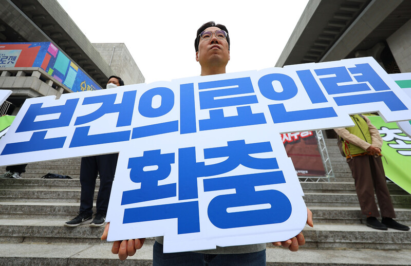 지난 7일 서울 세종문화회관 앞에서 열린 보건의료노조 서울지역본부 투쟁선포 기자회견에서 한 참가자가 구호가 적힌 피켓을 들고 있다. 연합뉴스