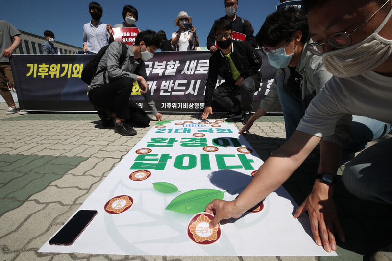 1일 오전 서울 영등포구 국회 정문 앞에서 열린 21대 국회 기후위기와 불평등 극복 요구 기자회견에서 기후위기비상행동과 한국환경회의 회원들이 퍼포먼스를 하고 있다. 연합뉴스