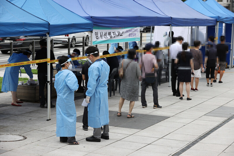 서울 중구 남대문시장 케네디상가에서 발생한 코로나19 집단감염에 이어 인근 중앙상가에서도 추가 확진자가 나온 가운데 11일 오후 시장에 마련된 임시선별진료소에서 시민들이 검사를 받기 위해 줄을 서고 있다. 연합뉴스