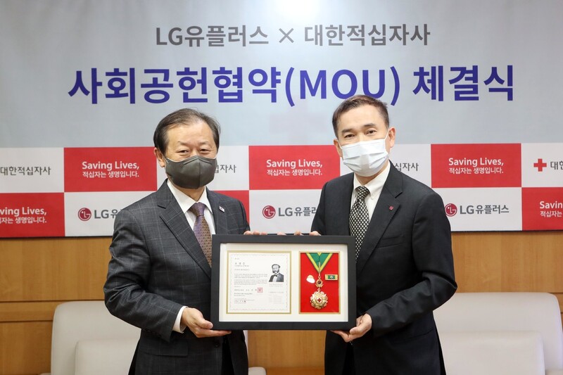 하현회(오른쪽) 엘지유플러스(LGU+) 부회장이 신희영 대한적십자사 회장으로부터 최고명예대장 인증서와 메달을 받은 뒤 기념사진을 찍고 있다. 엘지유플러스 제공