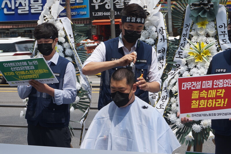 심상철 대우건설 노조 위원장이 지난 2일 서울 을지로4가 대우건설 본사 앞에서 열린 대우건설 매각대응 비상대책위원회 출정식에서 ‘졸속 매각 철회’를 주장하며 삭발하고 있다. 대우건설 노동조합 제공