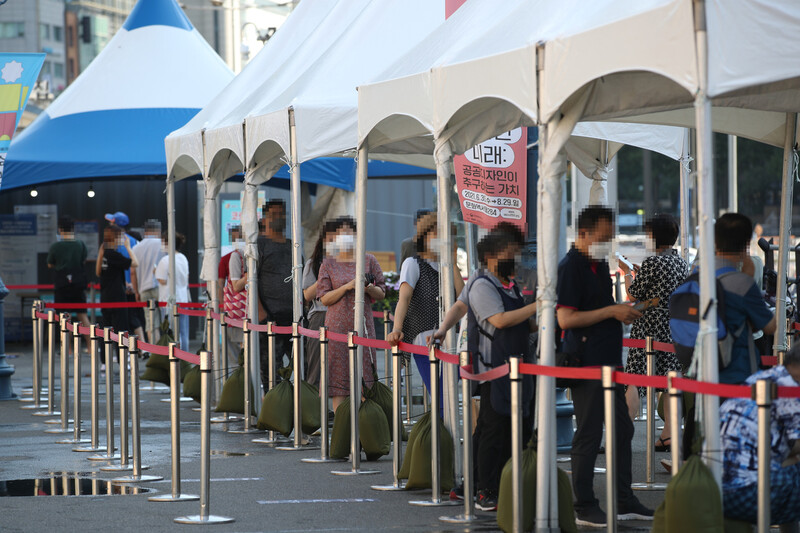 21일 오전 서울역 광장에 마련된 중구임시선별검사소에서 코로나19 진단 검사를 받기 위해 줄을 서 있다. 연합뉴스