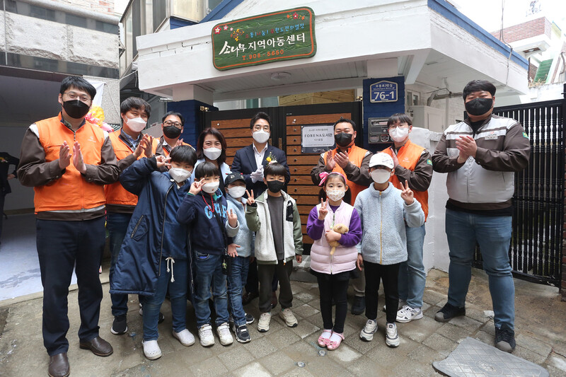 박혜진 소나무지역아동센터장(뒷열 왼쪽 네번째), 박세영 한화건설 전무(뒷열 왼쪽 다섯번째), 한화건설 봉사자와 아이들이 18일 청주 포레나 도서관 101호점 개관을 축하하고 있다. 한화건설 제공