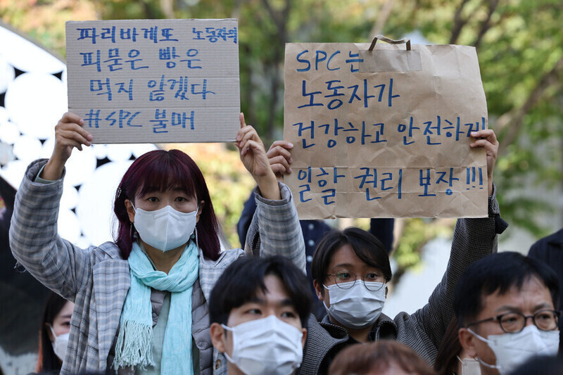 지난 20일 오후 서울 서초구 양재동 에스피씨(SPC) 본사 앞에서 열린 경기 평택 에스피씨 계열사 에스피엘(SPL)의 제빵공장 사망 사고 희생자 서울 추모행사에서 참가자가 손팻말을 들고 있다. 연합뉴스