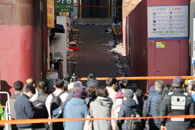 4일 서울 용산구 이태원역 1번 출구 앞 참사 추모 공간을 찾은 시민들이 사고 현장을 보고 있다. 연합뉴스