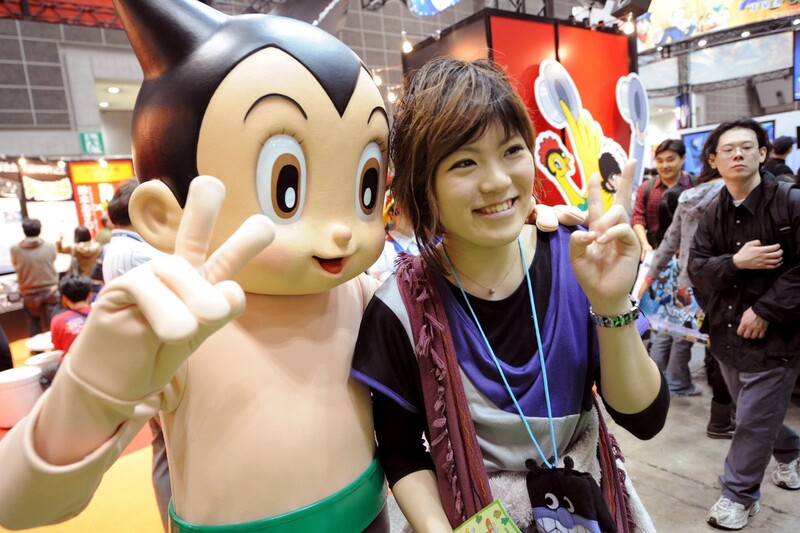2009년 도쿄 국제 애니메이션 박람회에서 한 관람객이 ‘아톰’(아스트로 보이) 캐릭터와 포즈를 취하고 있다. EPA 연합뉴스