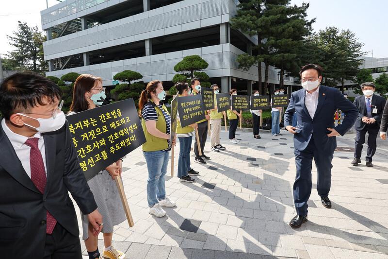 조규홍 보건복지부 장관이 16일 오후 서울 고려대학교 안암병원에서 현장 간담회에 참석하는 가운데 고려대 안암병원 간호사와 전국보건의료산업노동조합 조합원들이 윤석열 대통령의 간호법 제정안에 대한 대통령의 법률안 거부권 행사를 규탄하며 손팻말을 들고 있다. 연합뉴스