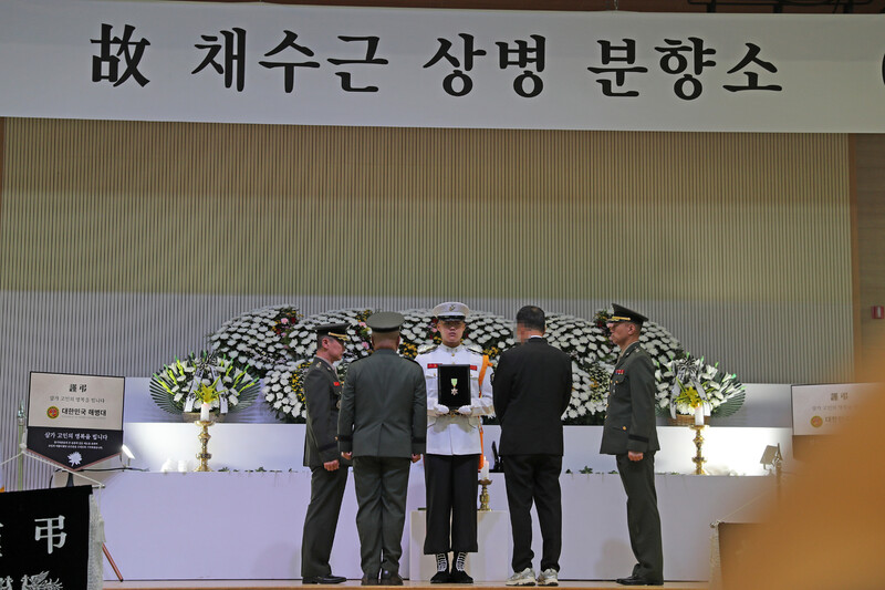 21일 경북 포항 해병대 1사단에 마련된 고 채아무개 상병의 분향소에서 김계환 해병대 사령관(왼쪽 둘째)이 고 채 상병의 보국훈장을 고인의 아버지(왼쪽 넷째)에게 전달하고 있다. 포항/연합뉴스