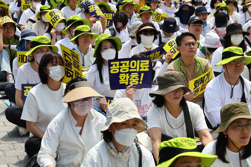 지난 6월27일 서울 용산구 대통령 집무실 인근에서 열린 감염병 전담병원 회복기 지원 확대 촉구 결의대회에서 보건의료노조 조합원들이 팻말을 들고 있다. 연합뉴스