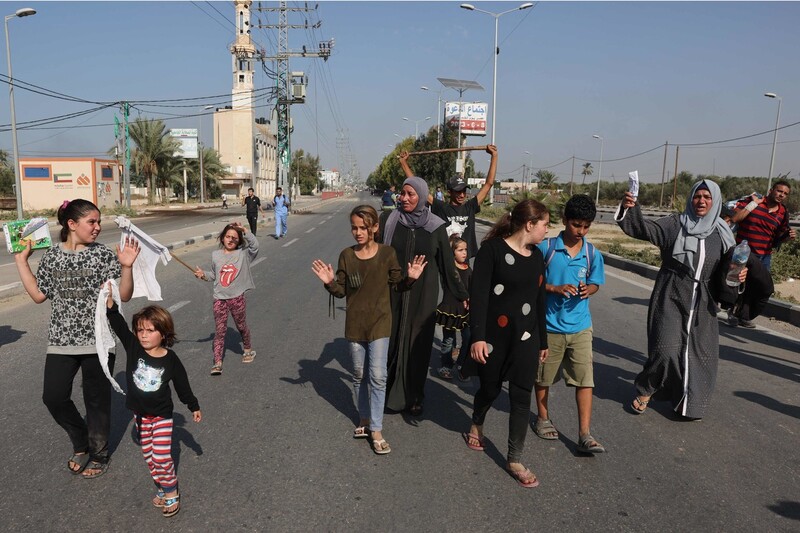지난 5일 이스라엘의 대피령에 따라 가자지구 북부에서 살라 알딘 도로를 통해 남부로 이동 중인 가족들이 흰색 깃발을 들고 두 손을 위로 올린 채 걸어가고 있다. AFP 연합뉴스