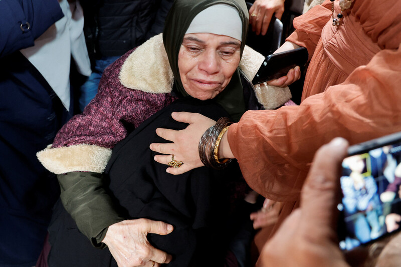 이스라엘과 하마스의 인질-수감자 맞교환 과정에서 풀려난 팔레스타인인이 서안지구 고향에 돌아와 가족 품에 안겨 있다. 로이터 연합뉴스