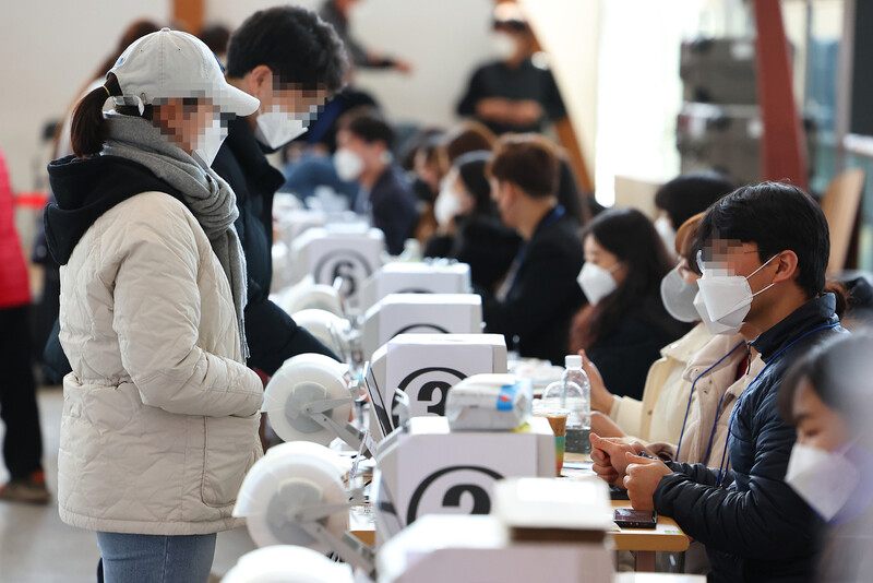 지난 5일 서울역 대합실에 마련된 사전투표소를 찾은 시민들이 투표 전 신분 확인을 하고 있다. 연합뉴스