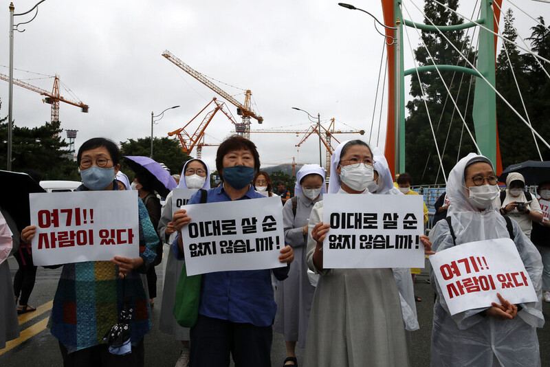 ‘대우조선 하청노동자들의 정당한 임금과 노동조건의 개선을 촉구하는 미사’에 참석한 활동가들과 수녀들이 손팻말을 들고 있다. 김혜윤 기자