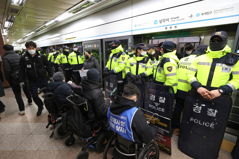 전국장애인차별철폐연대(전장연) 회원들이 지난 2일 오전 서울 지하철 4호선 삼각지역 승강장에서 지하철 탑승을 시도하는 가운데 경찰이 배치돼 있다. 연합뉴스