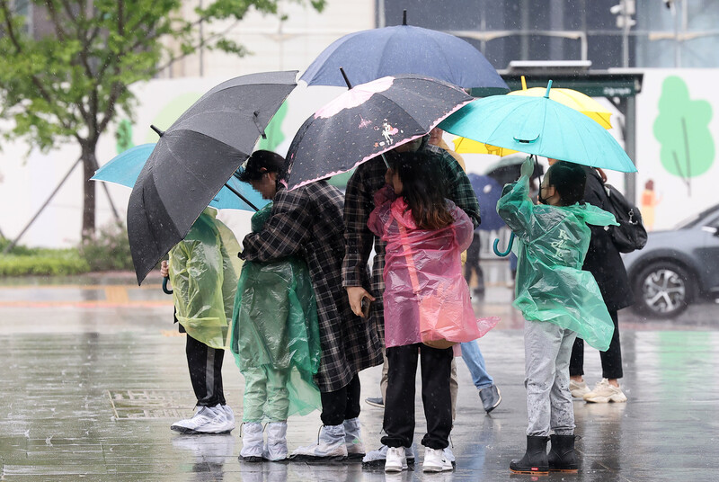 6일 서울 광화문 광장에서 시민들이 우산으로 비바람을 막고 있다.연합뉴스