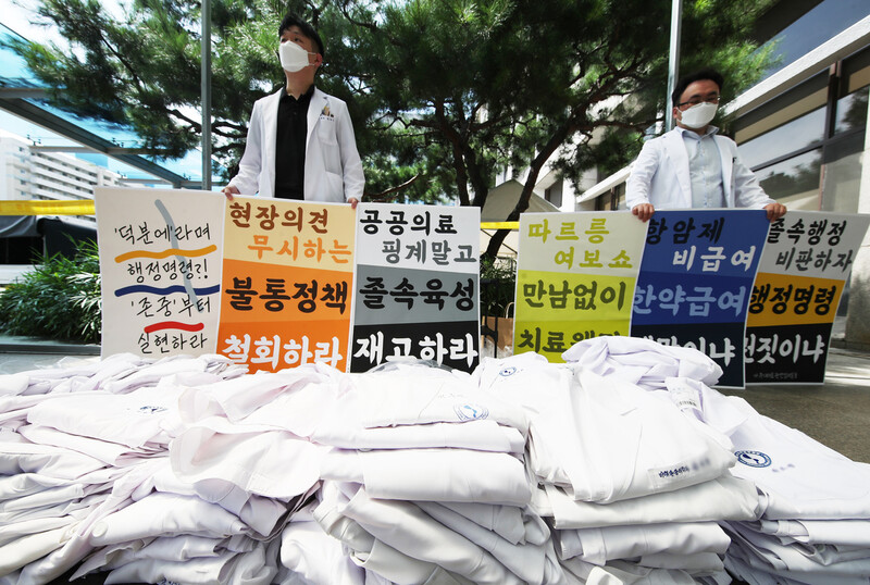 전국의사 2차 집단휴진 첫날인 26일 오후 경기도 수원시 아주대학교병원에서 의료진이 벗어놓은 가운 뒤에서 피켓 시위를 하고 있다. 연합뉴스