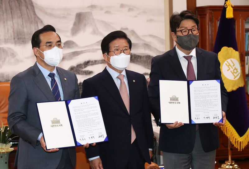 검찰의 수사-기소권을 분리하는 법안에 대해 여야가 박병석 국회의장이 제시한 중재안을 수용한 22일 오후 서울 여의도 국회의장실에서 박홍근 더불어민주당 원내대표(왼쪽)와 권성동 국민의힘 원내대표가 박병석 의장과 함께 합의문을 들고 기념촬영을 하고 있다. 공동취재사진