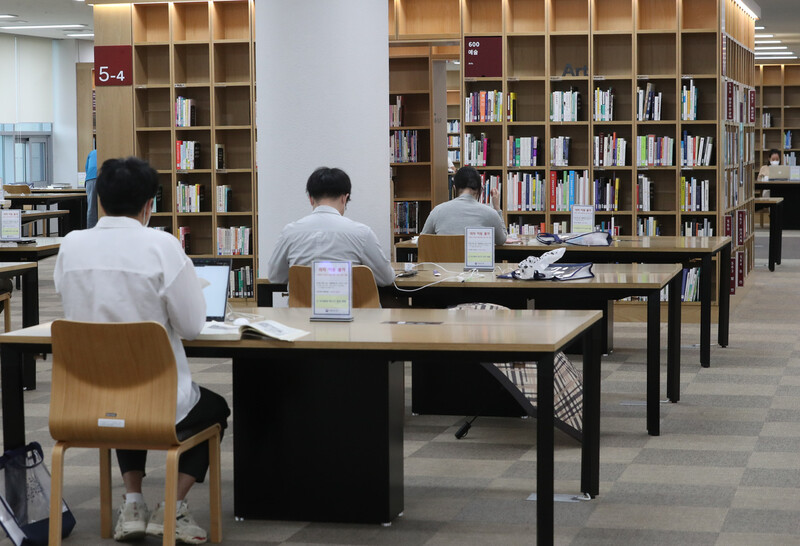 22일 재개관한 서울 서초구 국립중앙도서관을 찾은 시민들이 거리를 두고 앉아 책을 읽고 있다. 중앙재난안전대책본부의 공공시설 운영제한 조치 완화 결정에 따라 이날부터 재개관한 국립중앙도서관은 코로나19 확산 방지를 위하여 ‘사전 방문 예약’으로 운영한다. 연합뉴스