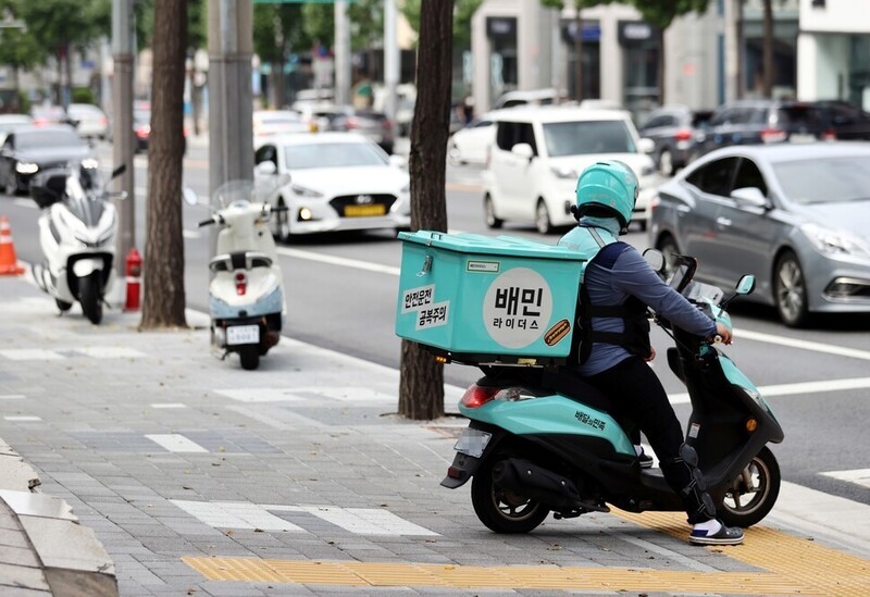 서울의 한 도로에서 배민라이더스 배달원이 잠시 멈춰서 신호를 기다리고 있다. 연합뉴스