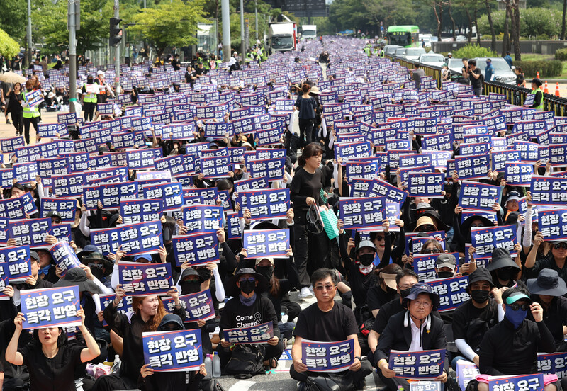 지난 26일 오후 서울 영등포구 국회의사당 앞에서 국회 입법 촉구 추모집회 참가자들이 손팻말을 들고 있다. 연합뉴스