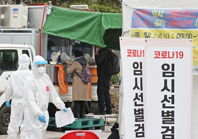 지난 21일 오전 서울 구로역광장에 마련된 임시 선별진료소 앞에 검체 검사를 받기 위해 긴 줄이 서 있다. 연합뉴스