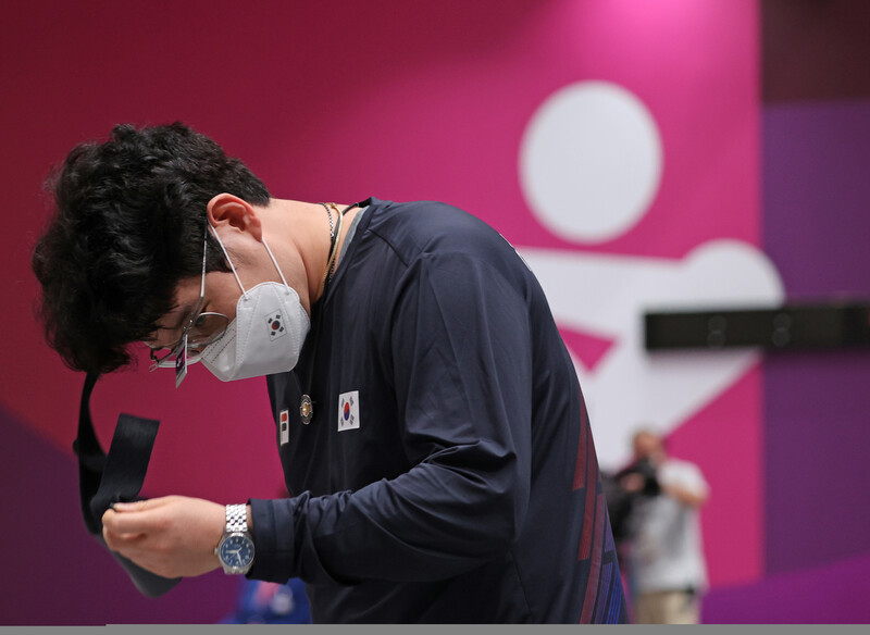 한국 남자 사격 대표팀 한대윤이 2일 도쿄 아사카 사격장에서 열린 도쿄올림픽 남자 25m 속사권총 결선을 4위로 마친 뒤 장비를 벗고 있다. 도쿄/연합뉴스.