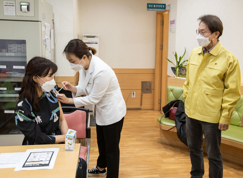 13일 오전 서울 서대문구 보건소에서 조희연 서울시 교육감이 홍제초등학교 보건교사 심연주씨의 접종을 지켜보고 있다. 사진공동취재단