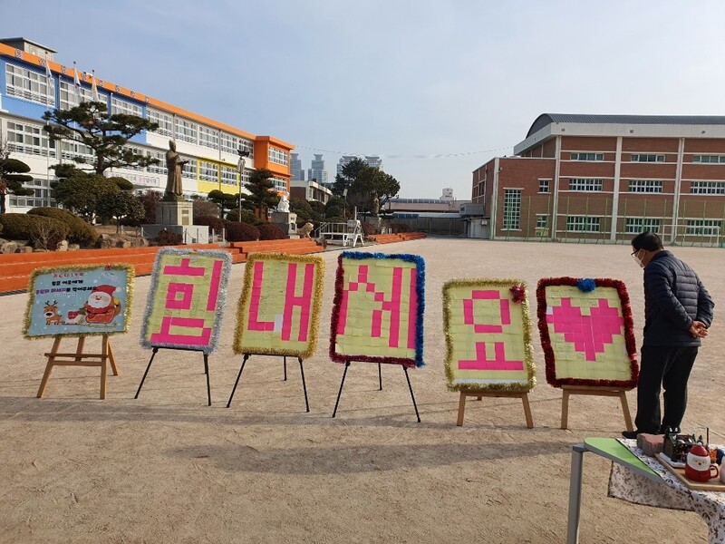 22일 울산 중앙초등학교 입구에 설치된 코로나19 극복 응원 메모판에 적힌 쪽지글들을 한 주민이 바라보고 있다. 연합뉴스