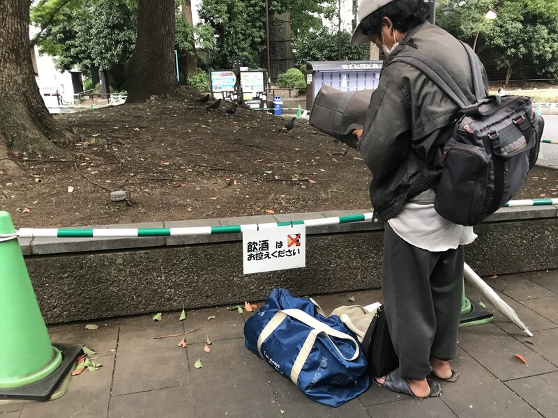 한 노숙인이 일본 도쿄 우에노 공원에서 음주 금지 안내문이 붙은 펜스를 바라보고 있다. 도쿄/이준희 기자