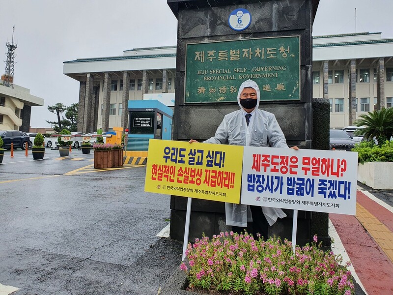 한국외식업중앙회 제주도지회(지회장 김병효)가 3일 오전 비가 내리는 궂은 날씨 속에 사회적 거리두기 4단계로 인한 어려움을 호소하며 집합금지와 영업시간 제한 완화 등을 요구하는 손팻말 시위를 벌이고 있다. 허호준 기자