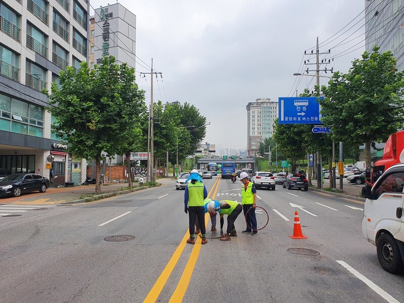 2020년 8월 도로 위에서 맨홀 점검을 할 때, 다른 안전장치 없이 라바콘만 세워둔 채 작업하고 있는 노동자들의 모습이다. 서총명 제공